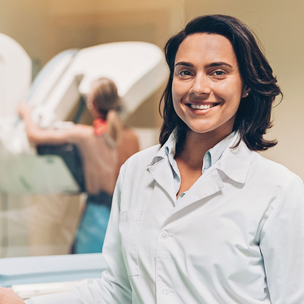 Women's imaging doctor giving mammogram